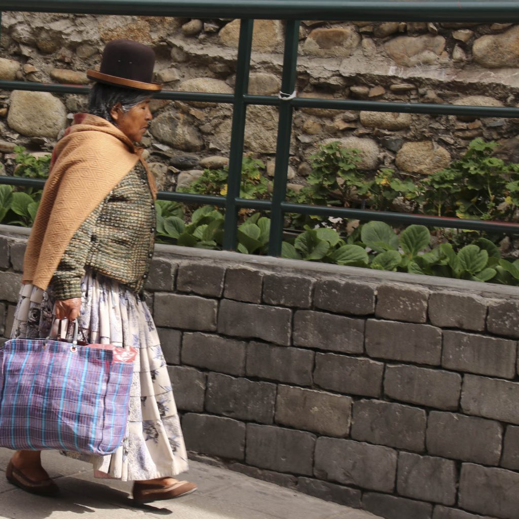 Photo from Thomas Kokta of woman is Bolivian cultural dress, walking the streets of La Paz.