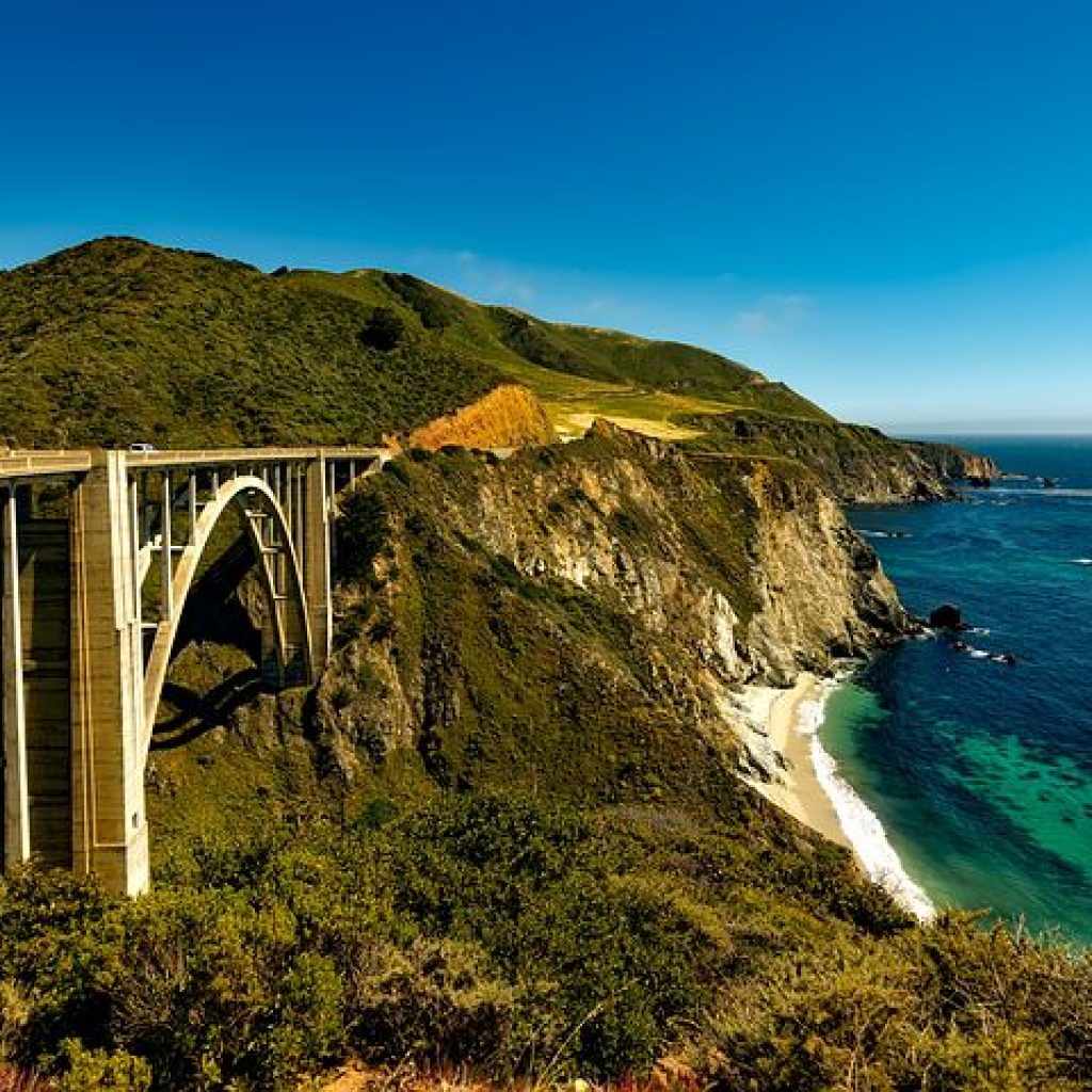 Photograph of California Coast off of the Pacific Coast Highway, featuring a road and bridge.